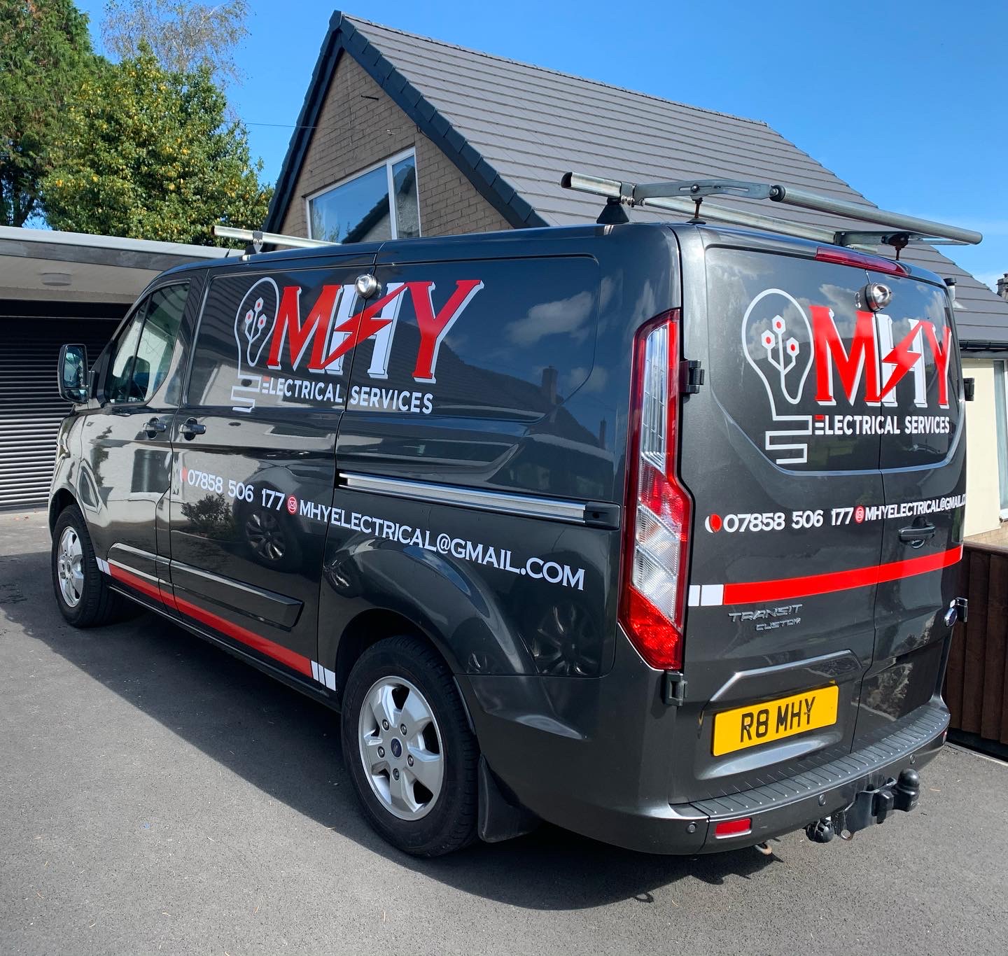 The MHY Electrical Services van, charcoal grey with red and white livery