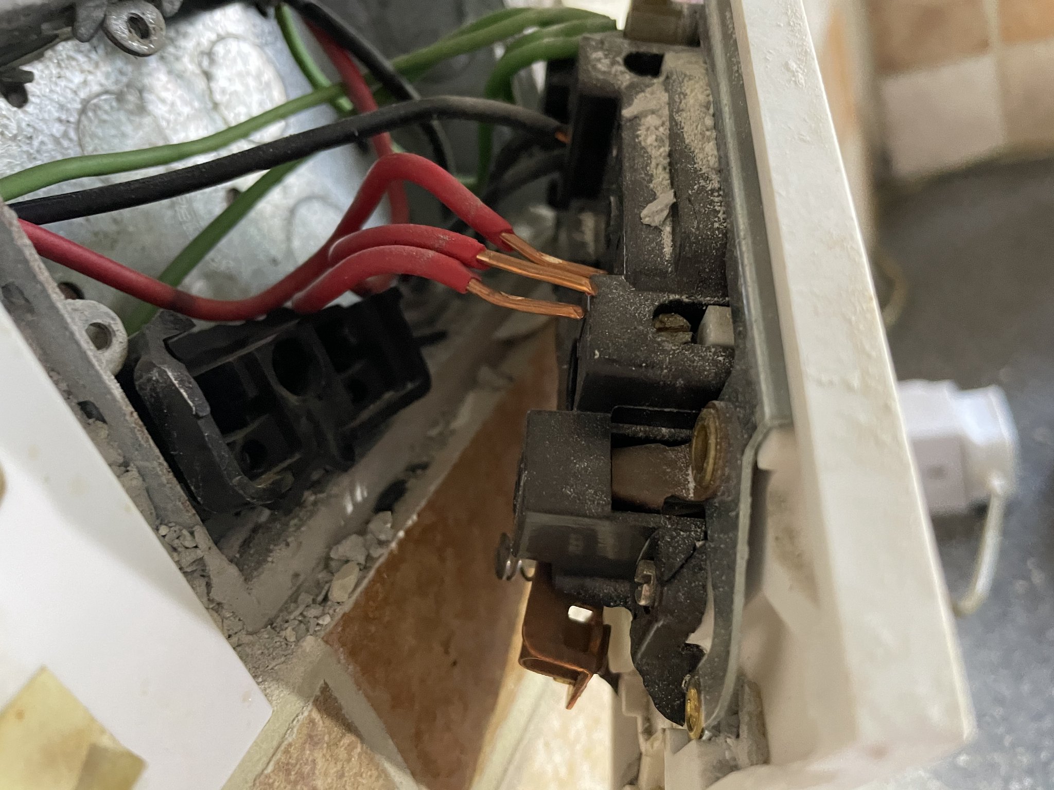 Scorched wiring behind a kitchen socket with a broken back