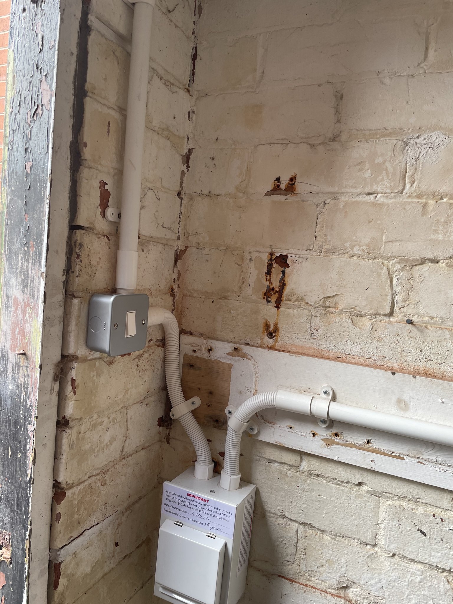 A new fuse board in a customer's garage with the wiring run in white conduit