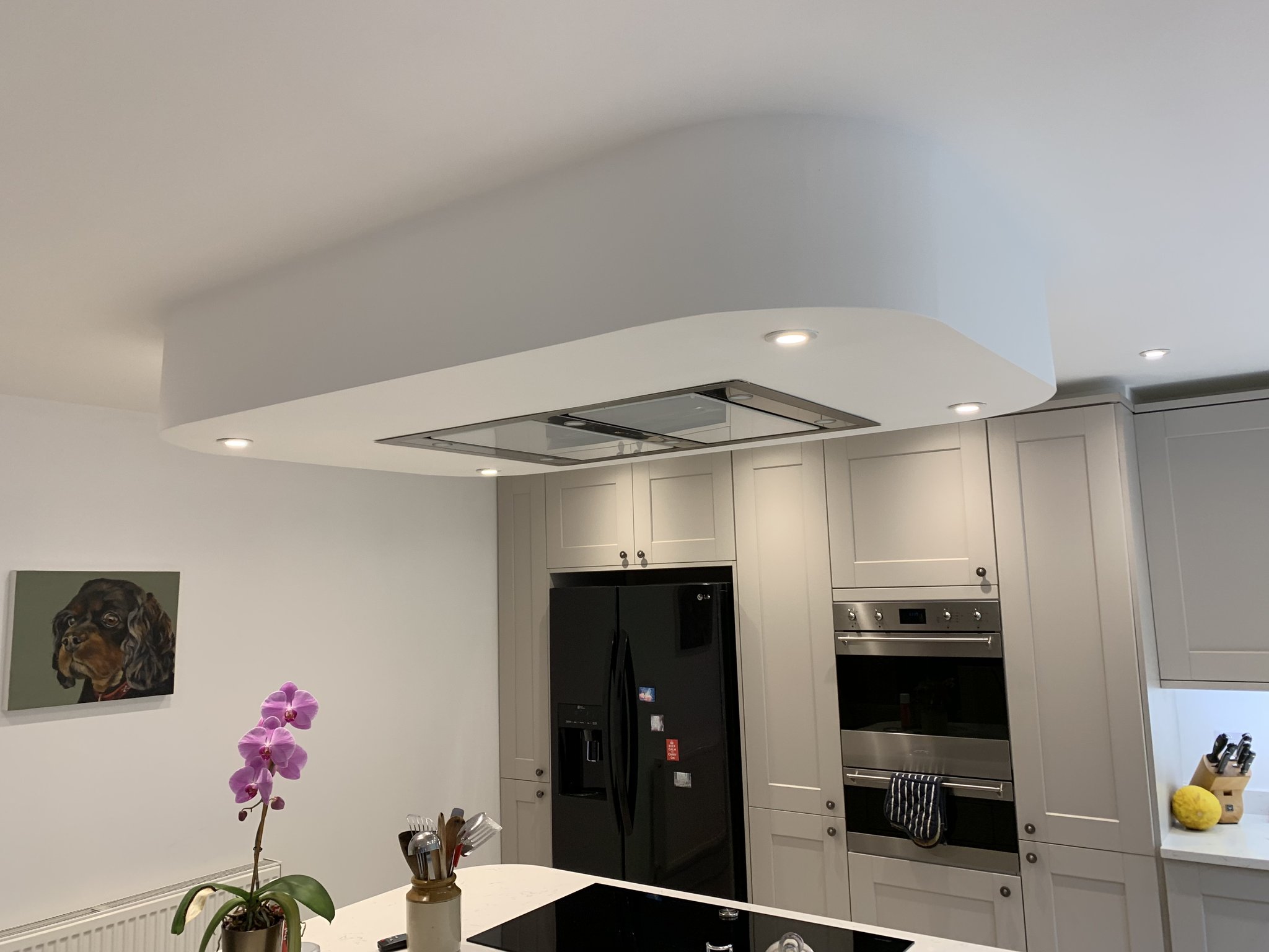 A kitchen with a ceiling extractor and recessed downlights installed