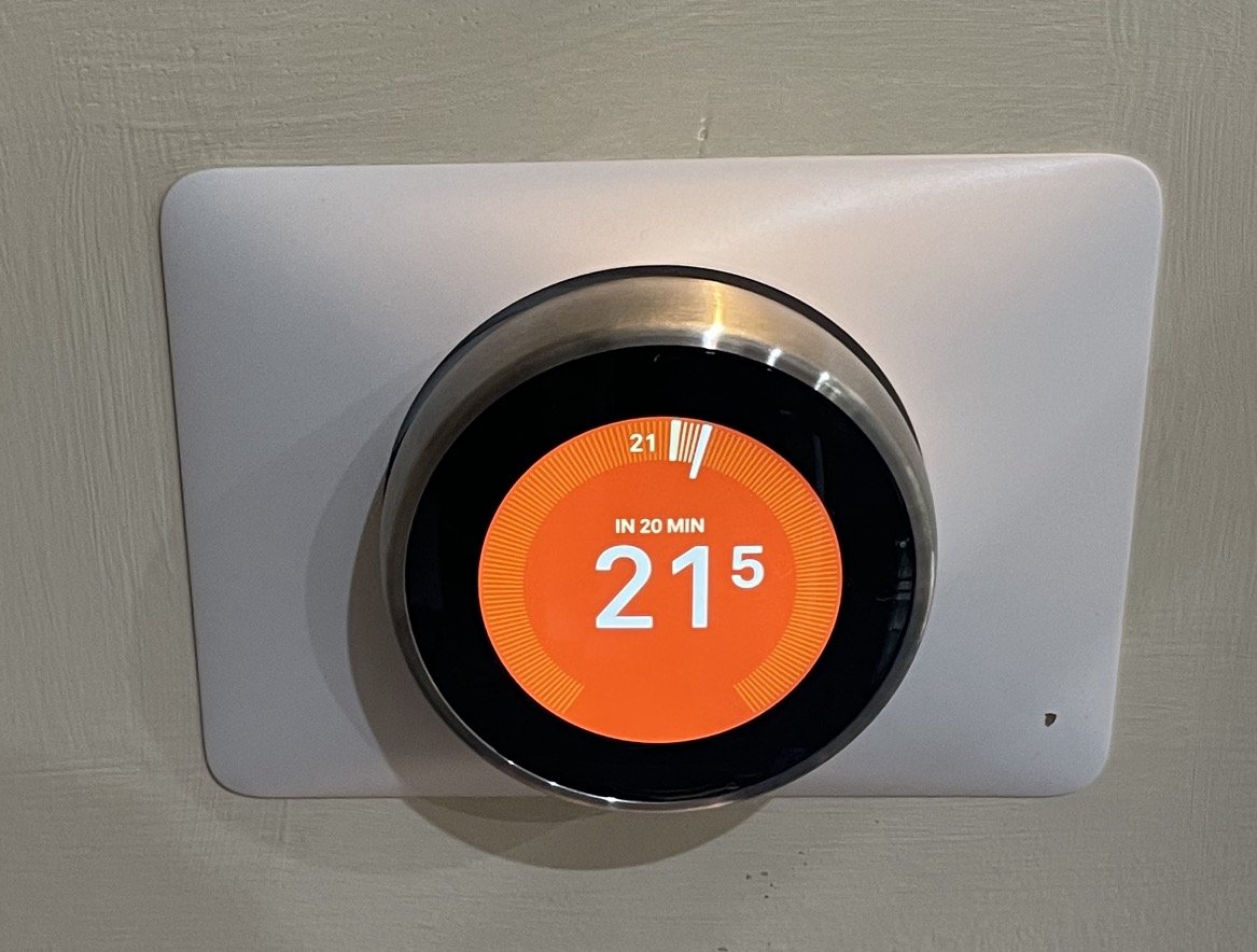 Close up of a Nest thermostat showing 21.5 degrees