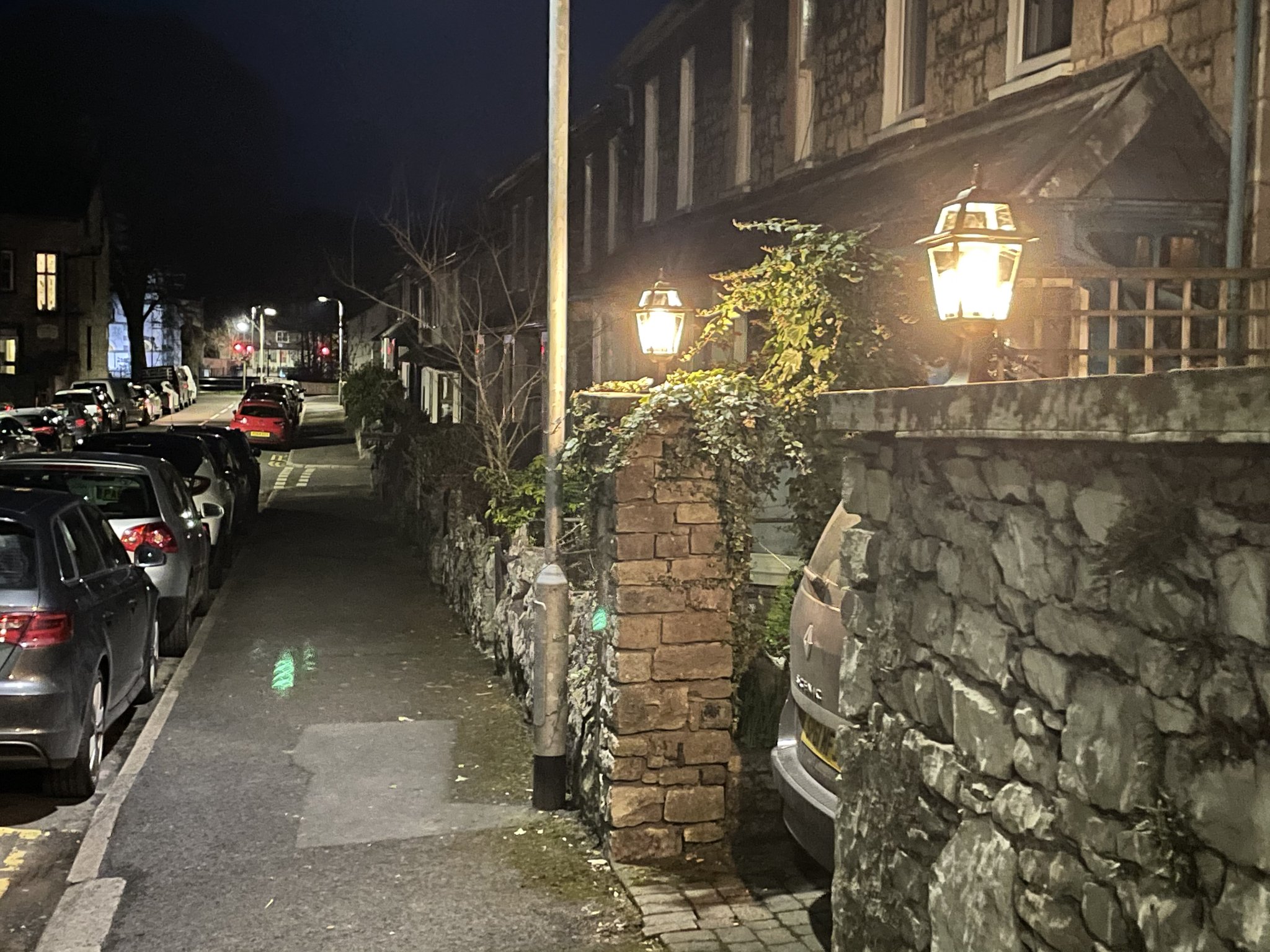 A traditional outside lantern lit at night on a stone terrace street